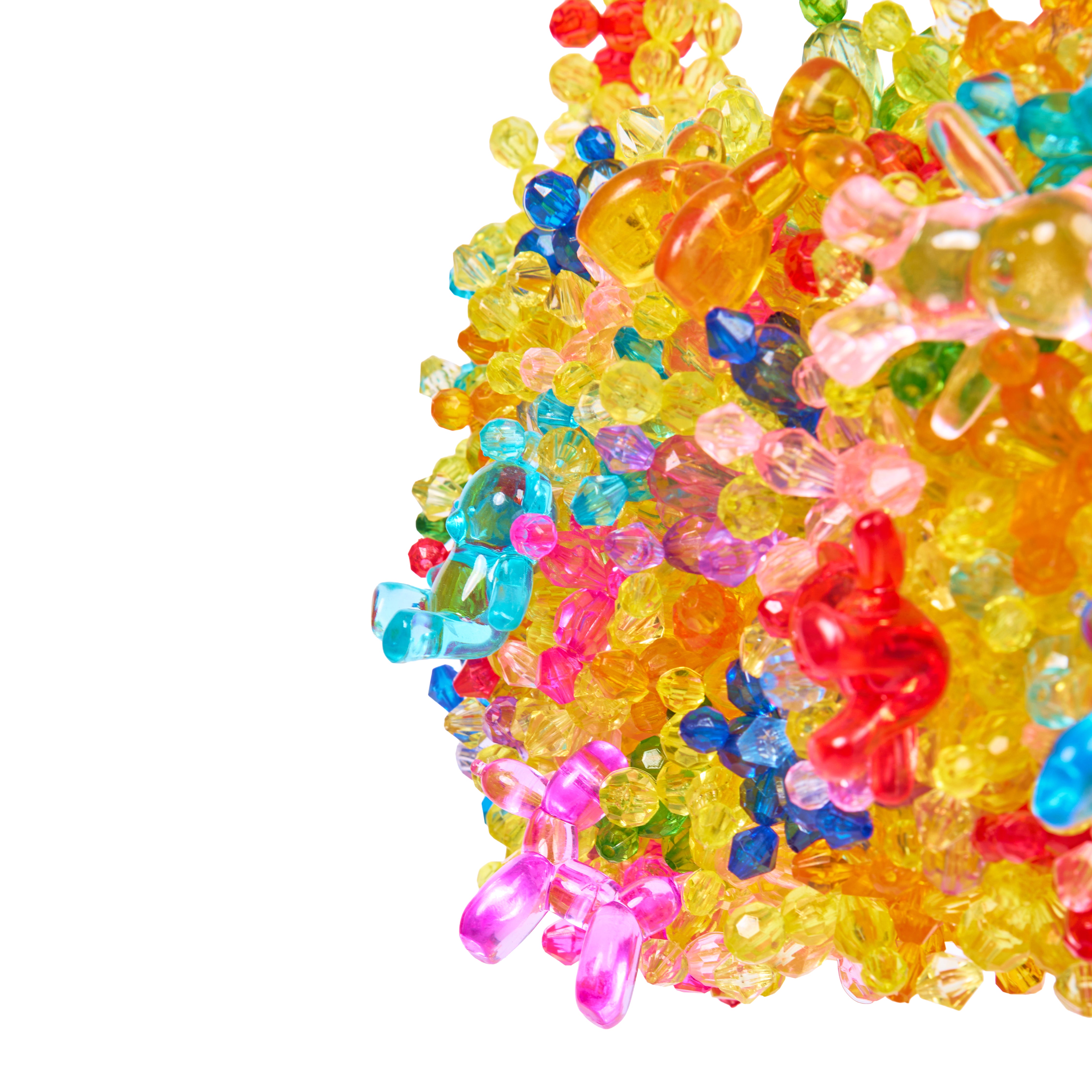 A close-up of a cluster of translucent, brightly colored plastic beads and small toy-like pieces in yellow, pink, blue, red, and orange on a plain white background.