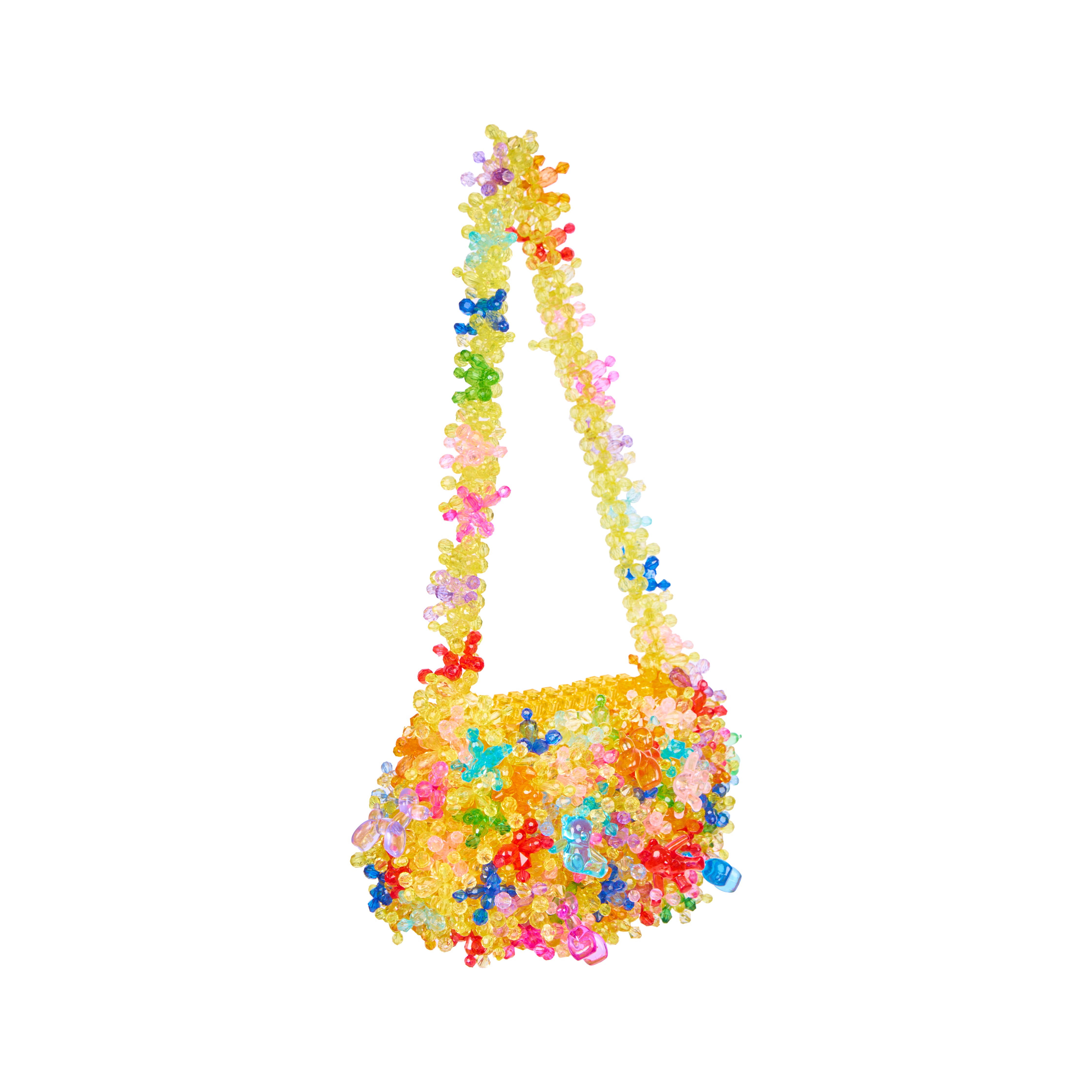 A small shoulder bag made entirely of colorful translucent gummy bear pieces, featuring a long strap and a textured body, isolated on a white background.